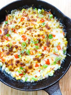 a skillet filled with food sitting on top of a wooden table