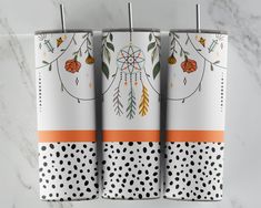 three white and orange towels hanging on a towel rack with polka dot dots around them