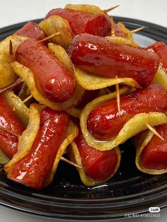 hot dogs and potato wedges on a black plate