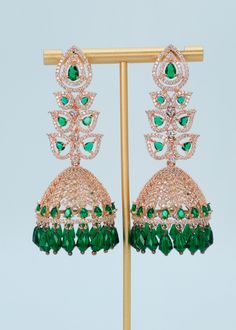 "Statement CZ Long Jhumki Earrings | Rose Gold Emerald Diamond Jhumki|Indian Jewelry |Pakistani Jewelry | Jhumkas | American Diamond Earrings A premium quality statement CZ long jhumki earrings with Monalisa Stone and Beads tassels. Add a pop of color with this trendy long Jhumki for a touch of sparkle in your festive looks. Length: Approx. 3\" Weight of each earring: 21 gms Push-Back closure  Finish: Rose Gold Polish High-quality brass as the base metal. Availability: In-Stock. *Color may vary slightly due to light condition & photography. Jewelry Care:  Keep away from moisture. Allow perfumes and lotion to dry before wearing. Store in jewelry pouch. Clean only with soft lint-free cloth." American Diamond Earrings, Beads Tassels, Photography Jewelry, Jewelry Pakistani, Jhumki Earrings, Earrings Rose Gold, Pakistani Jewelry, American Diamond, Gold Polish