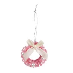 a pink and white wreath ornament hanging from a string