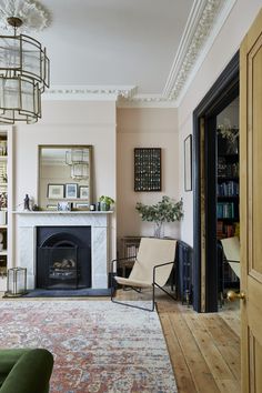 a living room filled with furniture and a fire place under a chandelier above a fireplace