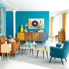 a living room with blue walls and yellow accents on the furniture in front of it