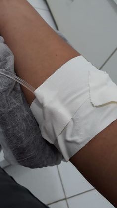 a person with bandages on their arm holding an iv