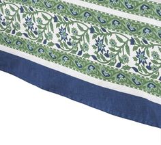 a blue and green table cloth with floral designs on the border is folded in half