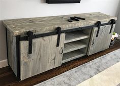 an entertainment center made out of wood with metal handles and sliding doors on each side