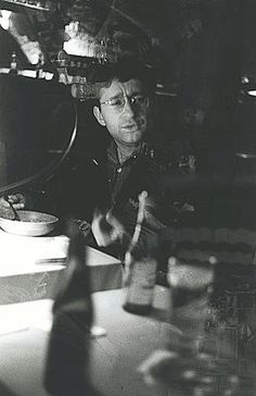 a black and white photo of a man sitting at a table