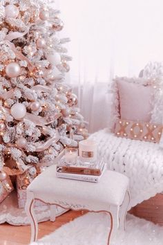 a white christmas tree with pink and gold ornaments in a living room decorated for the holidays