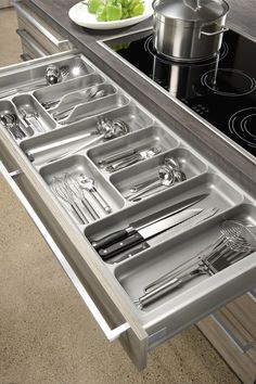 a stainless steel kitchen drawer with utensils in it