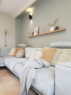 a living room filled with white furniture and lots of pillows on top of the couch