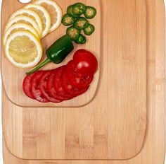 a cutting board with sliced up vegetables and lemons on it, as well as peppers