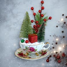 a tea cup filled with christmas decorations on top of a saucer