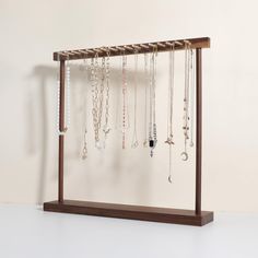 a wooden rack with many necklaces hanging from it