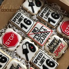 decorated cookies in a box with scissors, stop sign and other items on them for sale