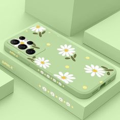 an iphone case with daisies and leaves painted on the back in pastel green