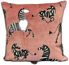 a pink pillow with zebras on it and an animal cut out in the middle