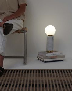 a person sitting on a chair next to a lamp