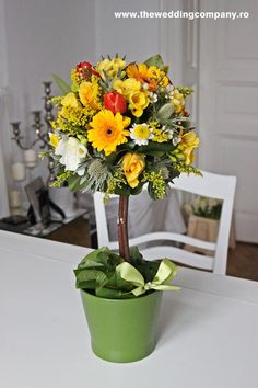 a flower arrangement in a green pot on a table