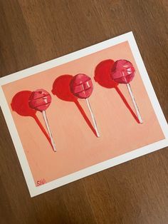 three red lollipops on a pink background