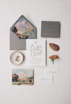 the wedding stationery is laid out on a white surface