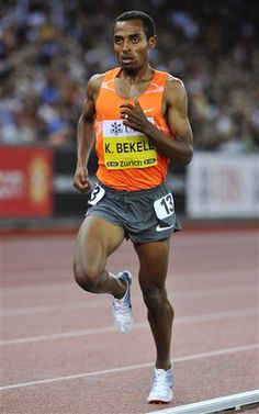 a man running on a track in an orange shirt