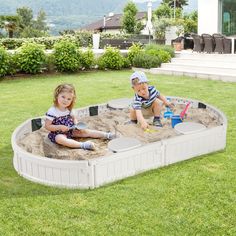 two children playing in an outdoor sandbox