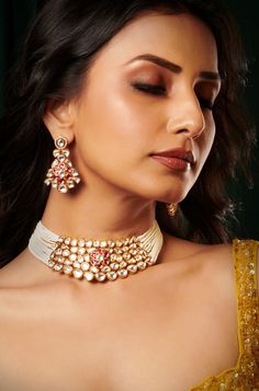 Embrace sophistication with this Kundan choker set, featuring delicate pearl lines and a charming pink floral center. Complete with exquisite dangler earrings, this set exudes elegance and is crafted with meticulous detail in mixed metal and 22kt gold plating. Finish: 22KT Gold Plating Material: Brass, Kundan,Pearls Color: Gold, White Size: Free Size, Adjustable Closure Type: Draw String Box Contains: 1 Necklace, 1 Pair Earrings Elegant Pink Chandbali Bridal Necklace, Elegant Pink Bridal Necklace For Festive Occasions, Elegant Pink Bridal Necklace For Festive Seasons, Elegant Pink Kundan Jewelry, Elegant Pink Kundan Necklace For Formal Occasions, Elegant Pink Kundan Necklace For Formal Events, Traditional Pink Kundan Necklace For Formal Occasions, Elegant Pink Meenakari Choker, Elegant Pink Jewelry Sets For Diwali