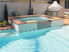 an empty swimming pool in the middle of a backyard with a bbq and grill