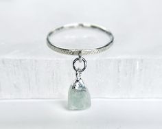 Showcase your love with this 7mm sterling silver raw aquamarine charm ring attached to your choice of a sterling silver smooth or textured band.  ✦100% handcrafted ✦ High quality .925 sterling silver and raw aquamarine gemstone ✦ Ring arrives in either a pink microfiber suede envelope/pouch or a blue/green drawer cardboard box as seen in the last image of this listing. ✦ Ready to ship in one business day ✦ Average shipping time (US/Canada/UK) three to five business days  ✦ Tracking available ✦Ra Minimalist Aquamarine Gemstone Rings, Minimalist Aquamarine Jewelry, Minimalist Aquamarine Promise Ring, Minimalist Aquamarine Ring Jewelry, Aquamarine Birthstone Ring In Fine Jewelry Style, Aquamarine Birthstone Crystal Ring In Fine Jewelry Style, Aquamarine Birthstone Ring Jewelry, White Gold Aquamarine Birthstone Jewelry, Minimalist Aquamarine Jewelry For Anniversary