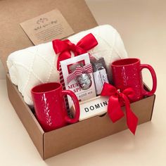 red coffee mugs and white towels in a gift box for someone's special occasion