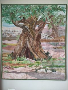 a wall hanging with an image of a tree in the middle and rocks behind it