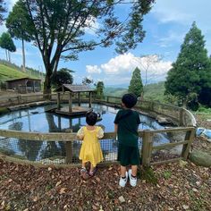 two children looking at a pond in the woods