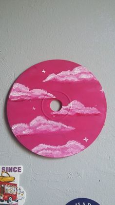 there is a pink disc with clouds painted on it