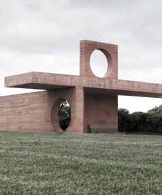 a large brick structure sitting on top of a lush green field