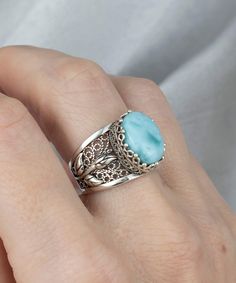 Look beautiful and feel blessed with our Filigree Art Larimar Gemstone Tulip Detailed Silver Women Statement Ring, crafted out of 925 Sterling Silver. With its handmade filigree art and stunning larimar gemstone, this ring is sure to bring luck and joy to whoever wears it! Make a statement with this breathtakingly elegant ring. This 925 Sterling Silver Women Cocktail Ring is the perfect gift for her. With its Filigree Art Tulip Detailed Gift Ring design and natural Larimar Gemstone, it's perfect Classic Sterling Silver Filigree Ring With Gemstone, Luxury Silver Filigree Ring With Gemstone, Elegant Oval Larimar Rings, Elegant Blue Larimar Rings, Unique Silver Larimar Rings, The Ring Face, Jewelry Designing, Statement Ring Silver, Sterling Silver Filigree