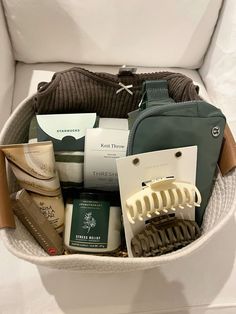 the contents of a travel bag are neatly organized in a white basket on top of a couch