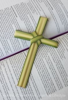 an open book with a cross on top of it and the pages folded in half