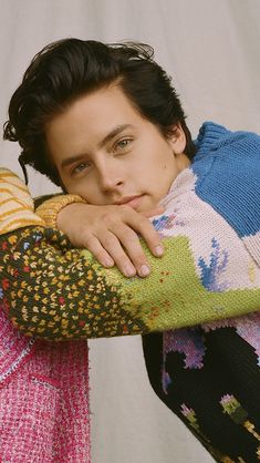 a young man with his arms folded over his shoulder