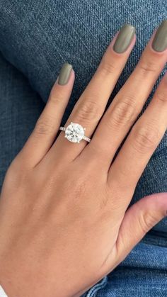 a woman's hand with a ring on her finger and an oval shaped diamond in the middle