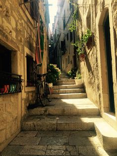 an alleyway with stone steps leading up and down to the building's windows