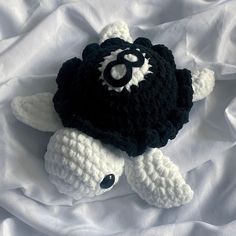 a crocheted stuffed animal laying on top of a white sheet