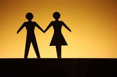 the silhouettes of two people are holding hands