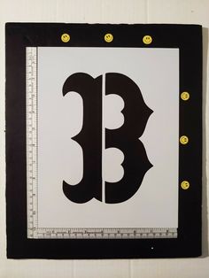 a black and white sign with yellow dots on it's sides that says b