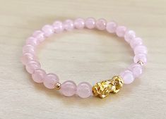 This is Pure Real 24 Karat Gold Pixiu/Natural Rose quartz / real 14k gold beads Real Gold Pixiu - Approximately 13mm x 6mm ( hollow , less than 1 g ) 14 karat Gold Beads Round - Approximately 3mm Natural Rose quartz - Approximately 6mm Hallmark/Stamp 999 for 24k Gold (PIXIU) Please select bracelet size. All are handmade with care .Strung on heavy duty stretchy/elastic. Products and photo may differ/beads color may vary. Bracelet Comes with Storage Bag & Box PIXIU/PIYAO ~ Secures Wealth and G Elegant Gold Crystal Bracelet For Meditation, Gold Bracelets With Rose Quartz And Natural Stones, Elegant Gold Rose Quartz Bracelets, Elegant Rose Quartz Gold Bracelets, Gold Beaded Bracelet With Rose Quartz Round Beads, Gold Beaded Bracelets With Rose Quartz Round Beads, Gold Beaded Bracelets With Rose Quartz, Gold Rose Quartz Beaded Bracelets With Round Beads, Elegant Gold Beaded Bracelets With Rose Quartz