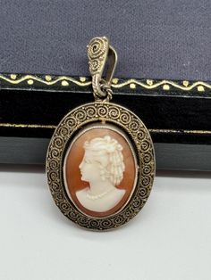 This is a beautiful vintage Theodor Fahrner sterling silver gilt cameo pendant. It is marked "TF" in a circle and "925". The pendant is in very good vintage condition with age and use related wear, there is tarnishing to the metal. The pendant measures approximately 1 3/8" by 3/4". Antique Cameo Medallion Jewelry, Ornate Cameo Jewelry For Anniversary, Vintage Intaglio Pendant Jewelry, Antique Cameo Jewelry For Anniversary, Vintage Cabochon Medallion Jewelry, Vintage Medallion Cabochon Jewelry, Victorian Cameo Pendant Jewelry, Ornate Round Cameo Jewelry, Formal Bronze Cameo Jewelry