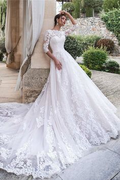 a woman in a white wedding dress posing for the camera with her hand on her head