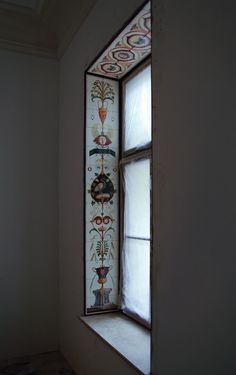 an old stained glass window in the corner of a room