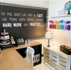 an office with a chalkboard on the wall that says hard work and practice