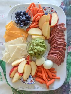 a white plate topped with lots of different types of fruit and vegtables