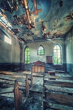 an old church with stained glass windows and wooden pews